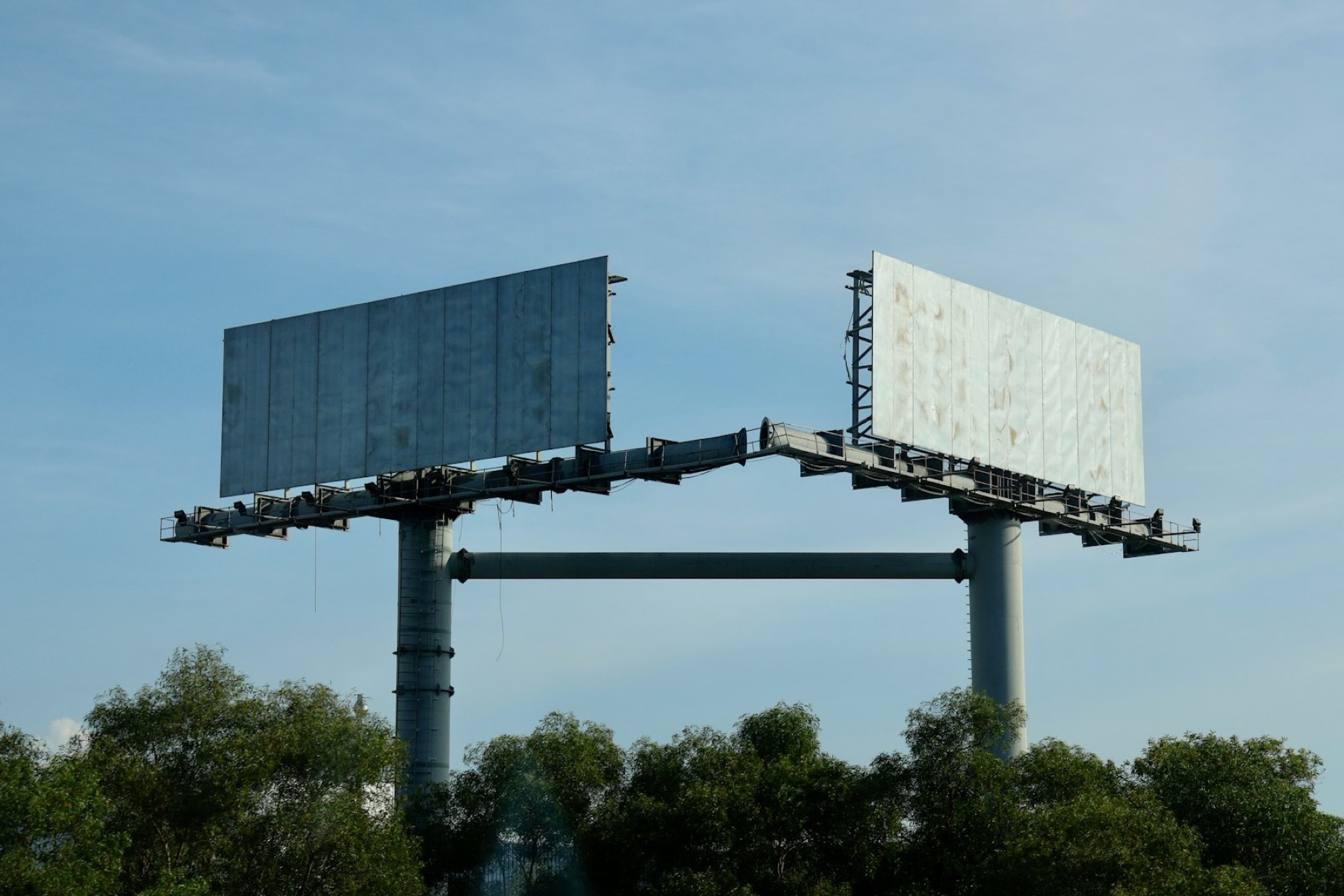 Two billboards against a blue sky