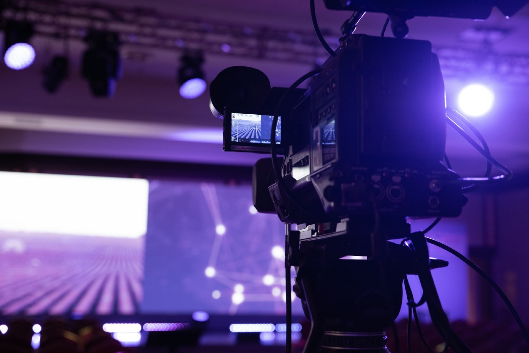 Television camera filming a lit stage