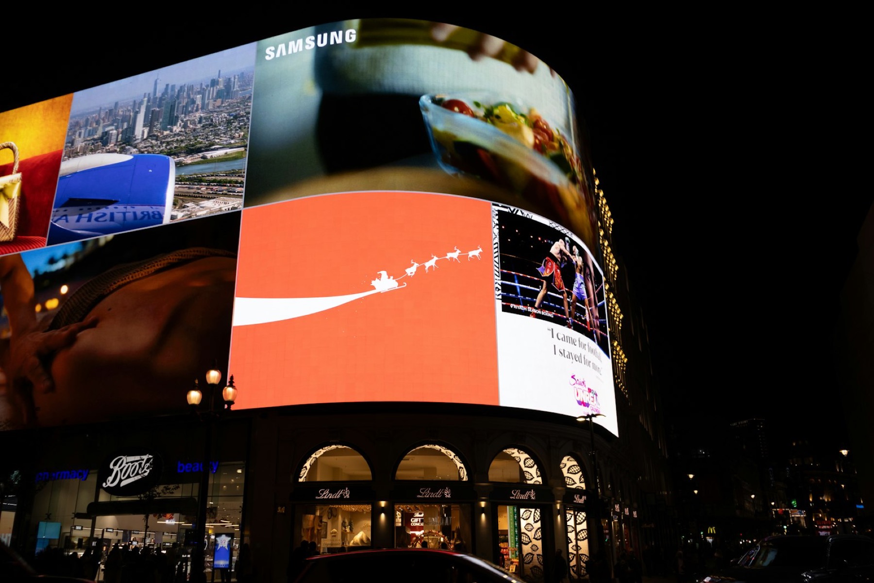 Digital billboards lighting up a city street at night